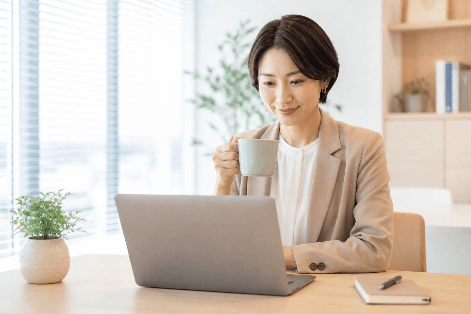 経理担当が PC で仕訳を確認しているイメージ